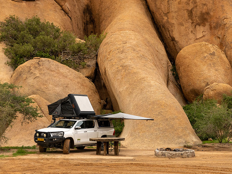 Asco 4x4-Mietwagen f&uuml;r Selbstfahrer mit ge&ouml;ffnetem Dachzelt in der N&auml;he der Spitzkoppe im Damaraland