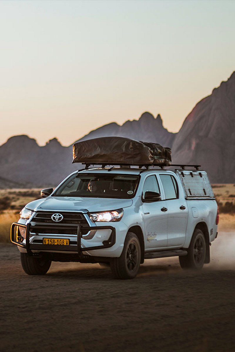 Asco Budget-safarivoertuig voor 1&ndash;2 personen met daktent op een onverharde weg in Namibi&euml;