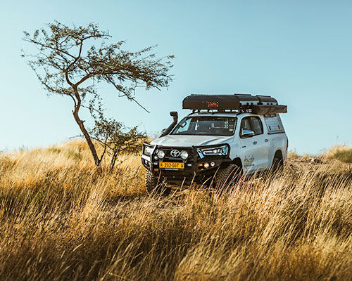 Asco Toyota Hilux 4x4 Car Rental with two Rooftop Tents driving in Namibian Landscape