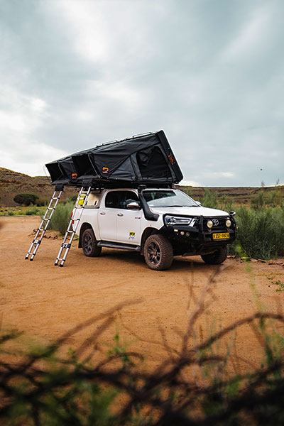 Asco Toyota Hilux Safari 4x4-Mietwagen mit zwei Dachzelten beim Camping in der namibischen Landschaft