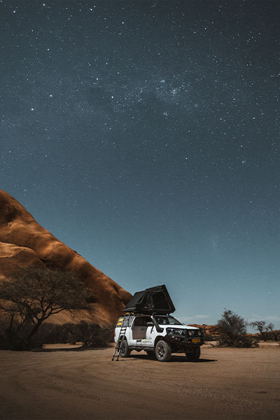 Asco 4x4-huurauto met kampeeruitrusting in Namibi&euml; om te kamperen onder de donkere sterrenhemel en de Melkweg op een afgelegen camping