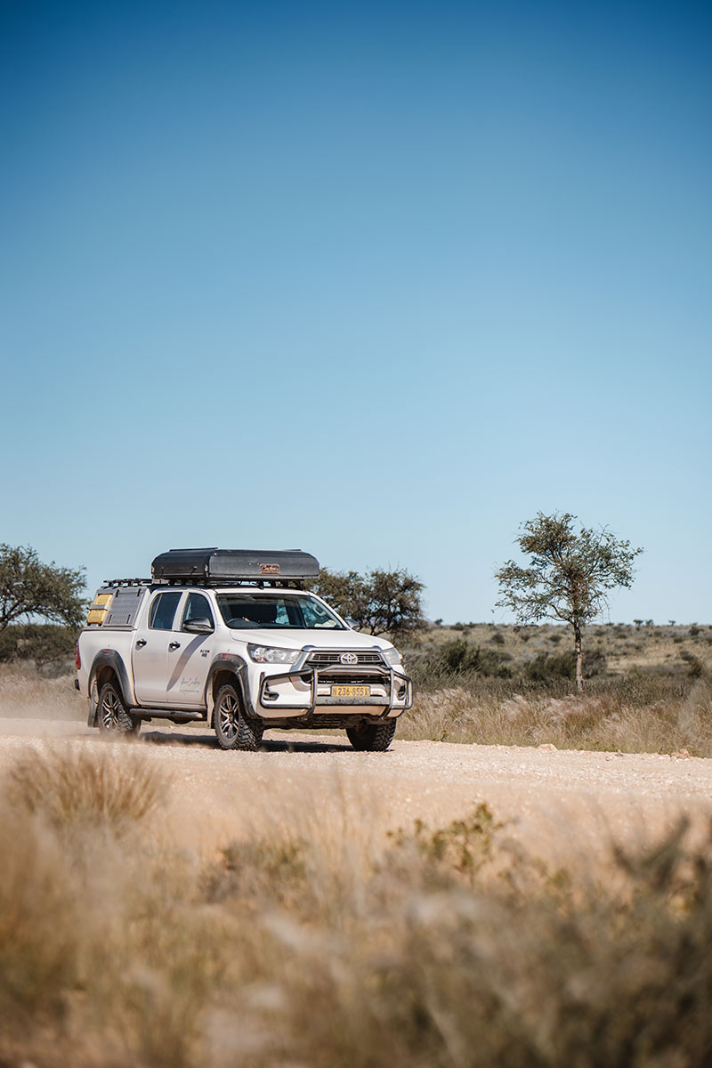 Asco autohuur voor self-drive met kampeeruitrusting op een stoffige weg in Namibi&euml;