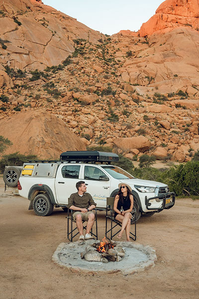 Reizigers met een 4x4-huurauto en kampeeruitrusting bij Spitzkoppe in Damaraland